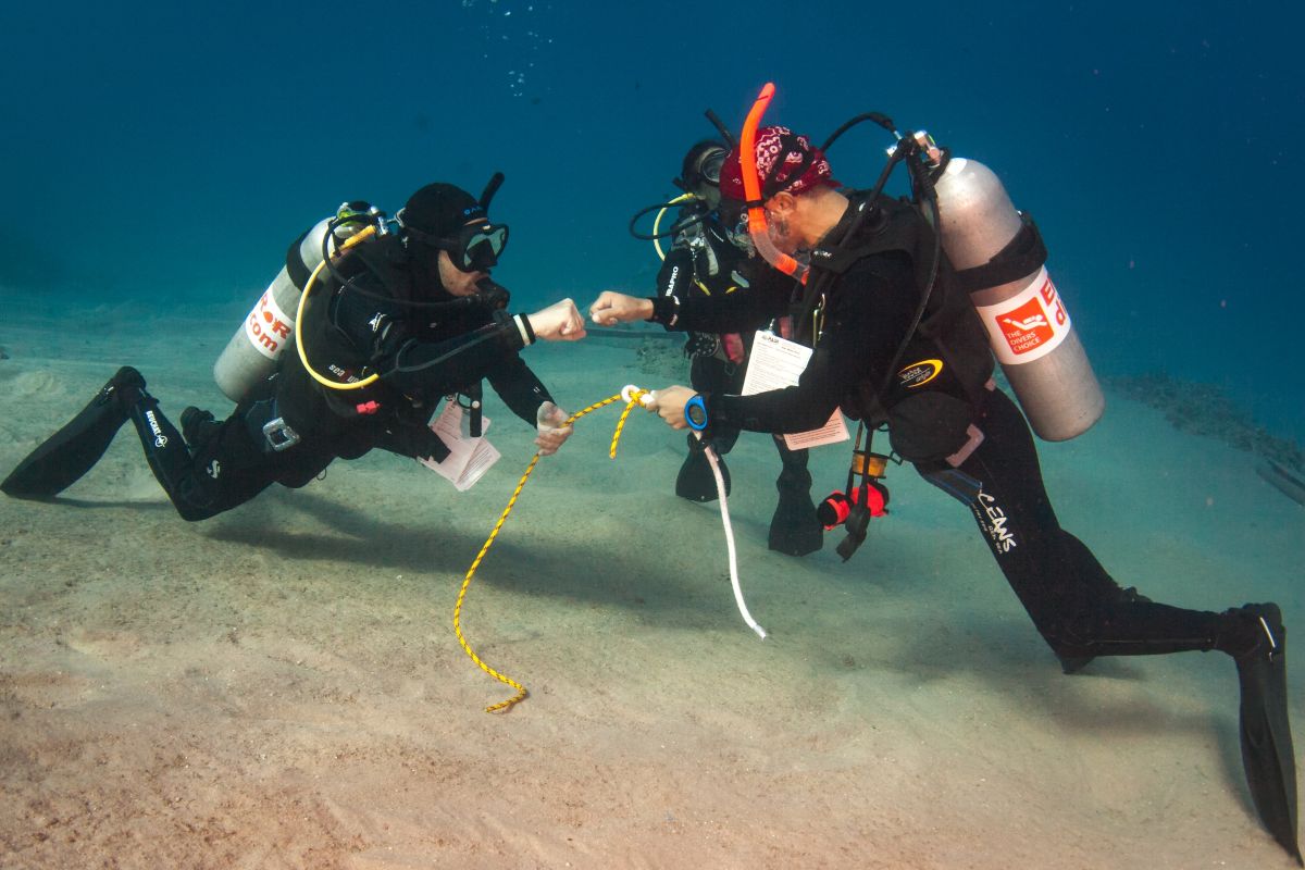 Tutor and pupil share a fist pump during their scuba diving course