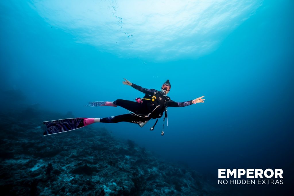 A female diver happily explores the Indian Ocean in the Maldives